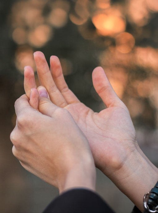 Close up on hands rubbing arthritic knuckles in discomfort