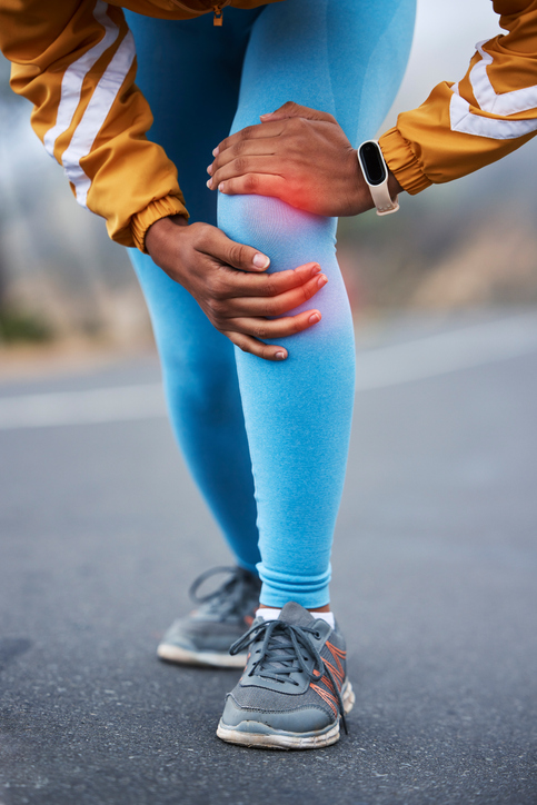 Close up on woman holding her knee with pain from running